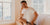man sitting on bed in underwear