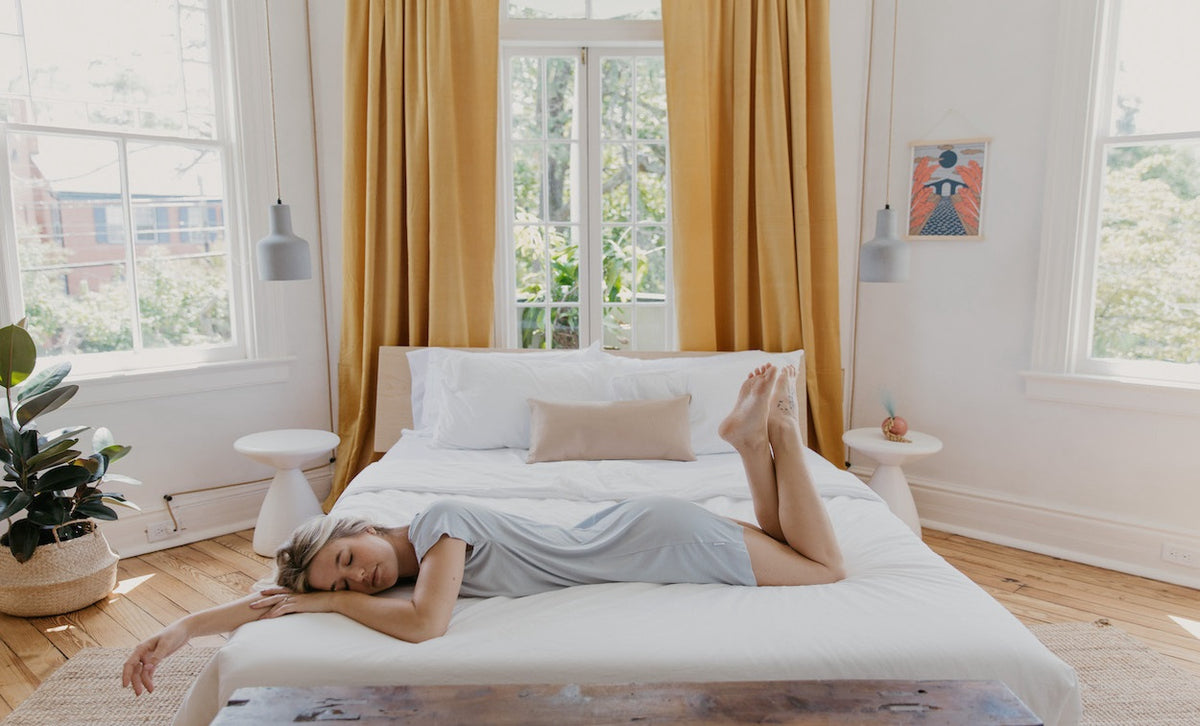 Woman in loungewear almost asleep on bed